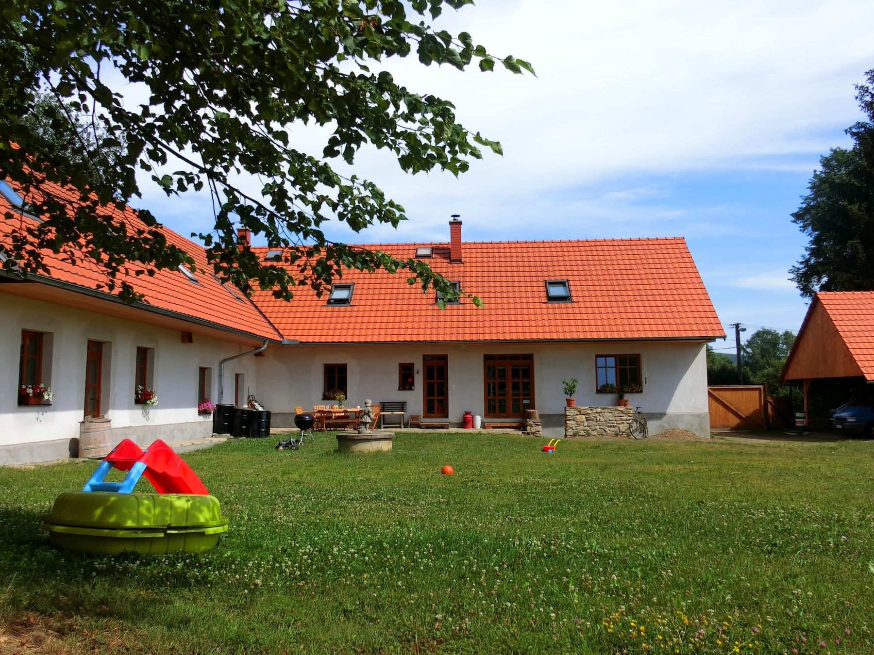 Dvůr statku s trávníkem a dětskými hračkami